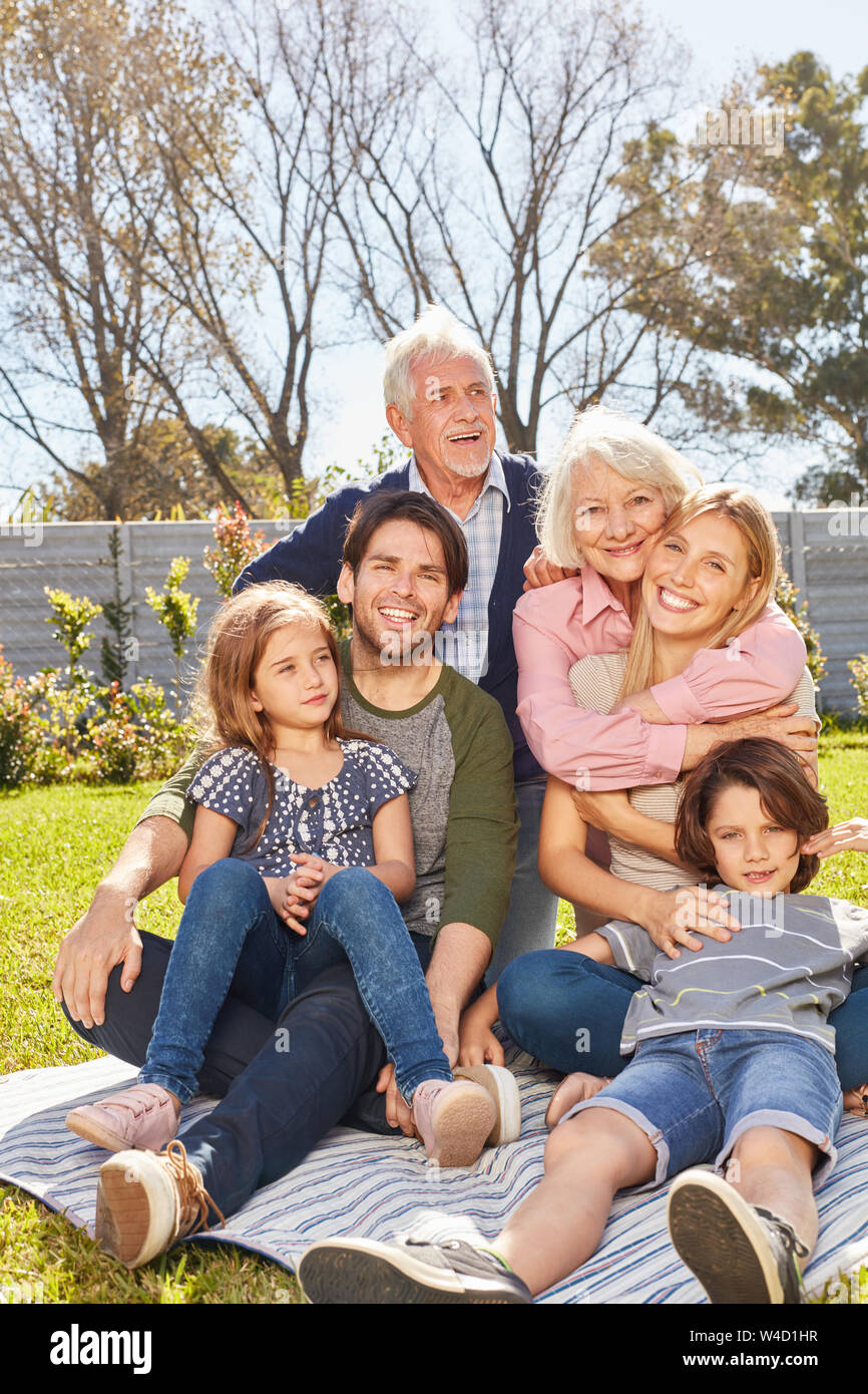 Glückliche Familie mit Kindern und Großeltern zusammen im Garten im Sommer Stockfoto