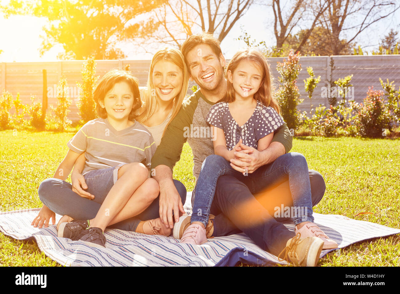 Glückliche Familie sitzt mit zwei Kindern im Sommer im Garten Stockfoto