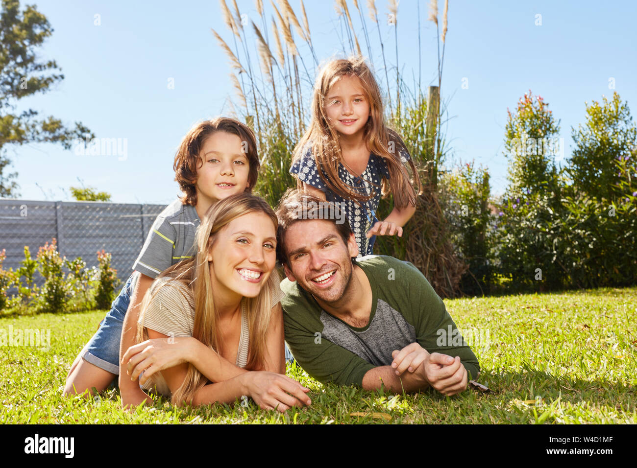 Glückliche Eltern und zwei Kindern im Sommer auf Urlaub in der Natur auf einer Wiese Stockfoto