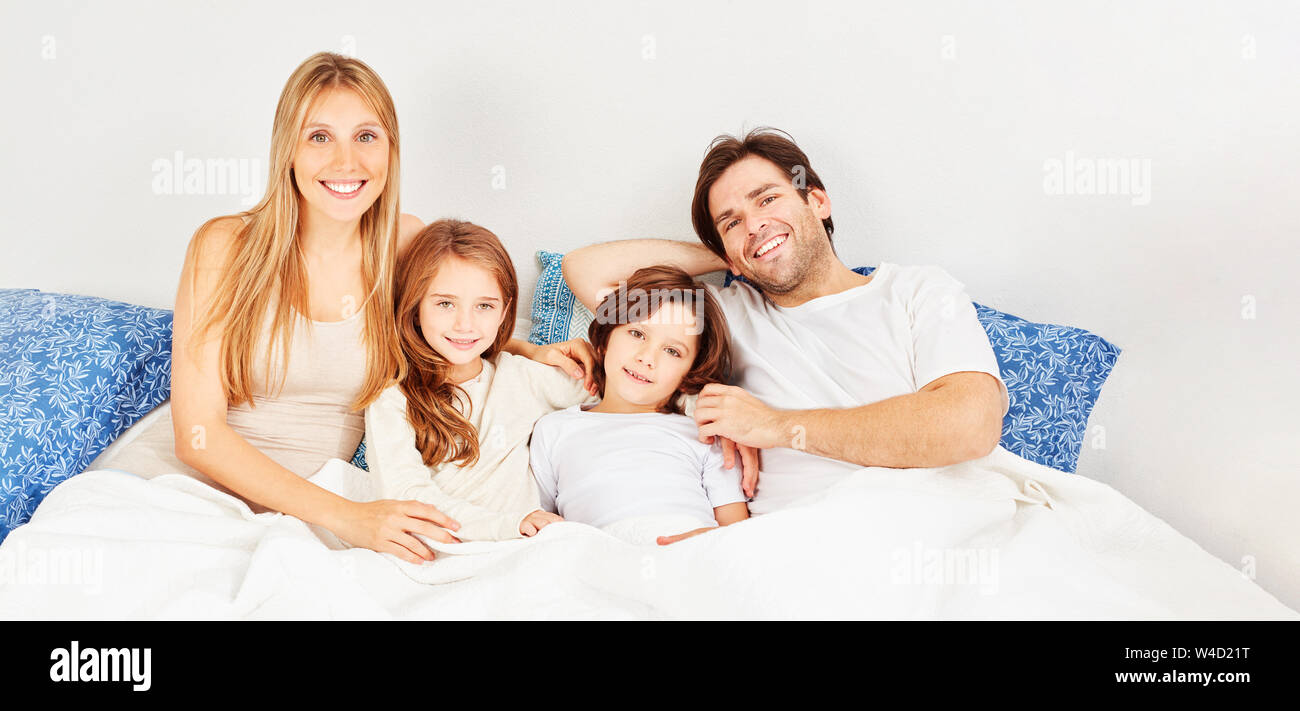 Glückliche Familie mit zwei Kindern in den Morgen im Bett als Header Stockfoto