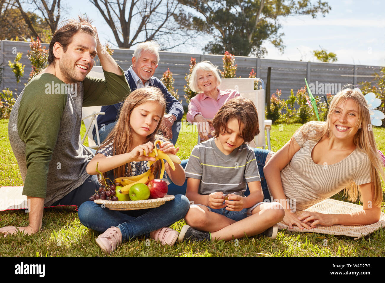 Familie mit Kindern und Großeltern ist bei einem Picknick im Sommer Garten Stockfoto