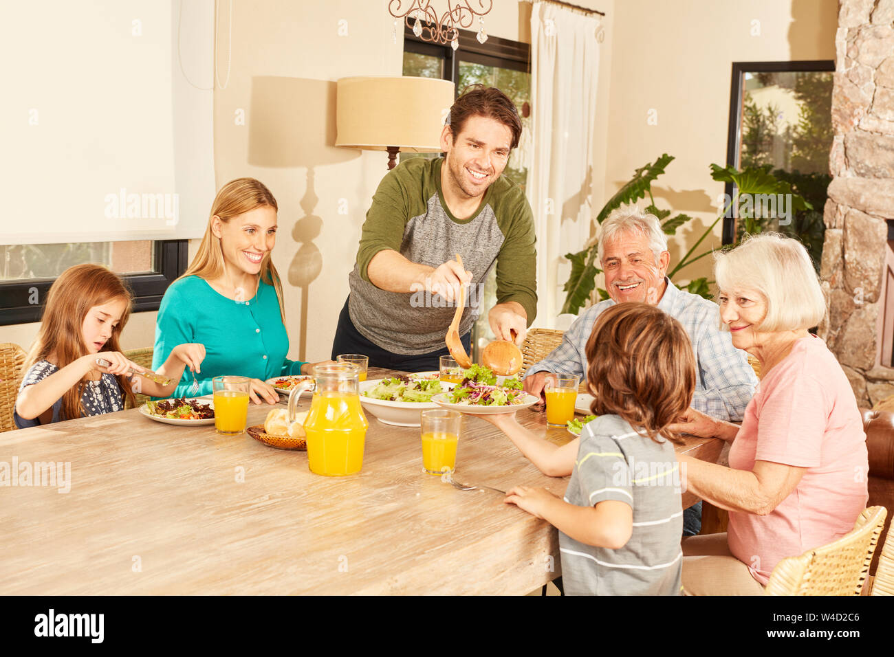 Erweiterte Familie mit Großeltern und Kindern beim Mittagessen in der Esstisch Stockfoto