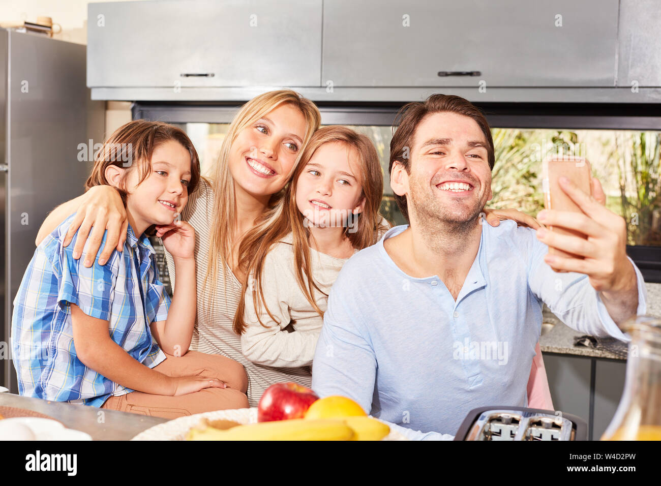 Glückliche Eltern und zwei Kinder machen eine selfie in der Küche Stockfoto