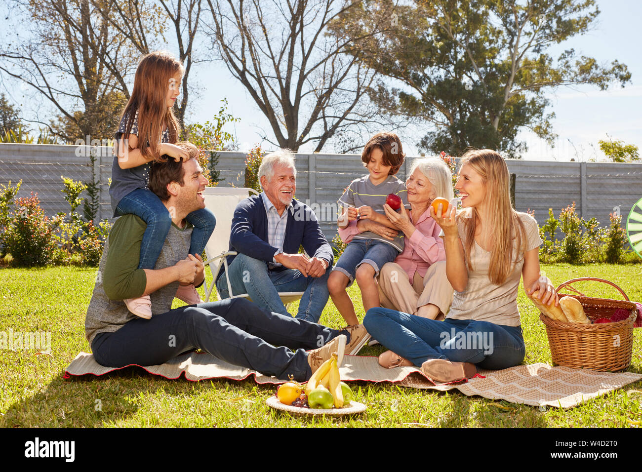 Erweiterte Familie mit Kindern und Großeltern bei einem Picknick im Garten im Sommer Stockfoto