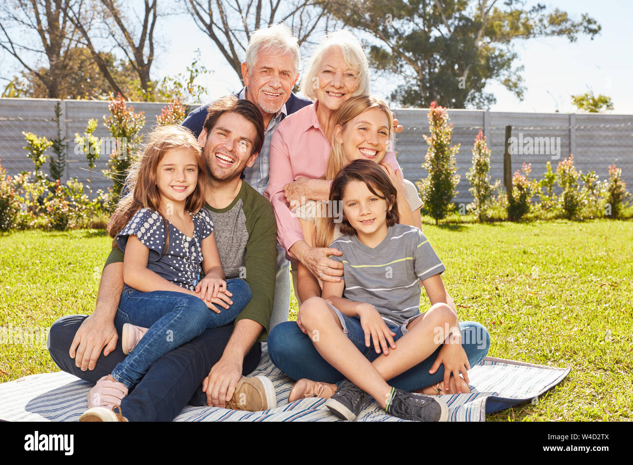 Glückliche Familie mit Kindern und Großeltern im Sommer im Garten Stockfoto
