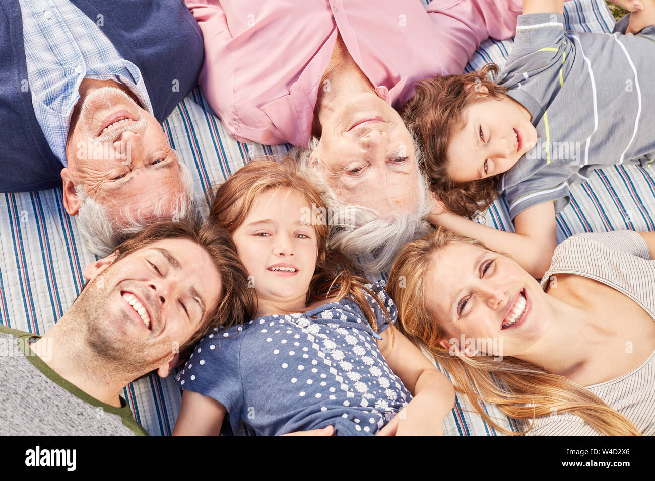 Glückliche Familie mit Kindern und Großeltern liegt zusammen Stockfoto