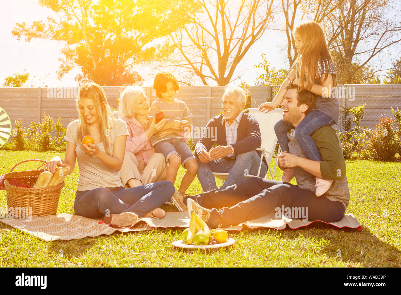 Erweiterte Familie mit Kindern und Großeltern mit Picknick im Garten im Sommer Stockfoto