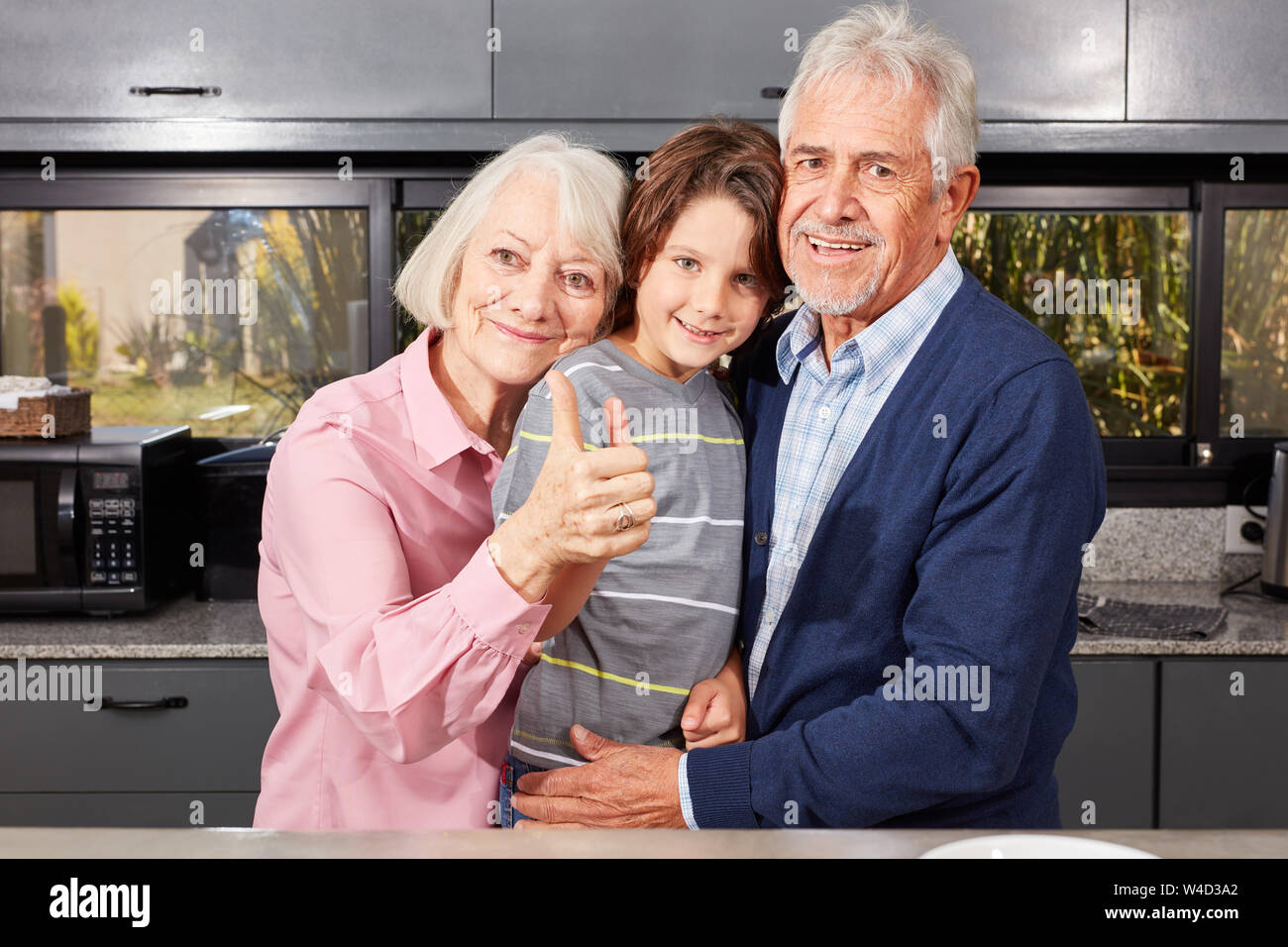 Großeltern als Oma und Opa zusammen mit ihren Enkel zeigen die Daumen nach oben Stockfoto