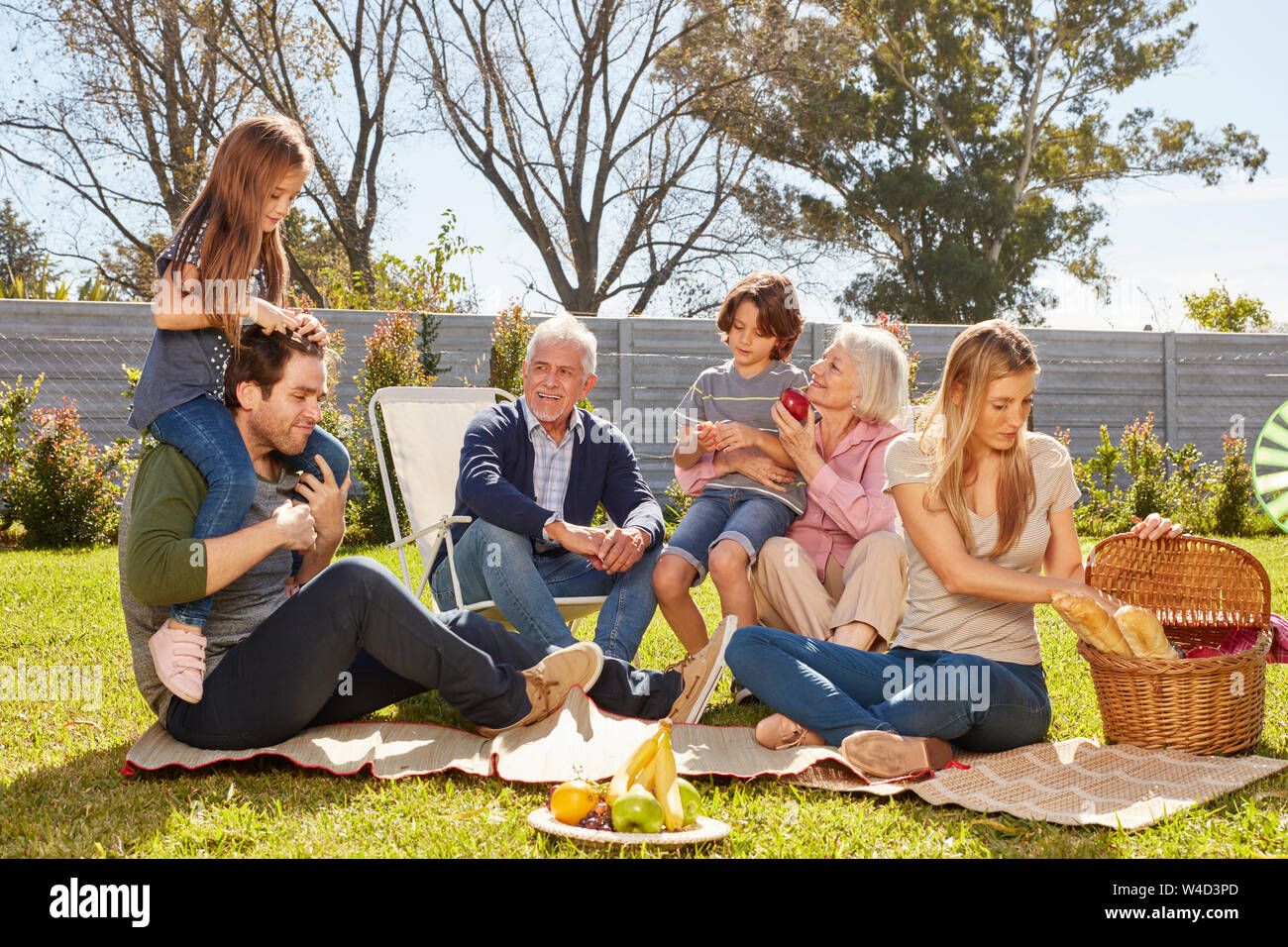 Erweiterte Familie mit Kindern und Großeltern mit Picknick im Garten im Sommer Stockfoto