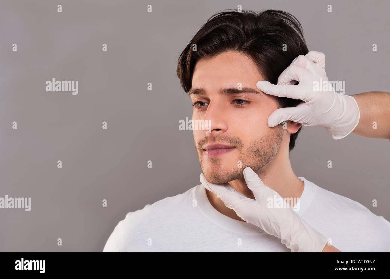 In Handschuhen berühren männlichen Patienten eine Kosmetikerin Stockfoto