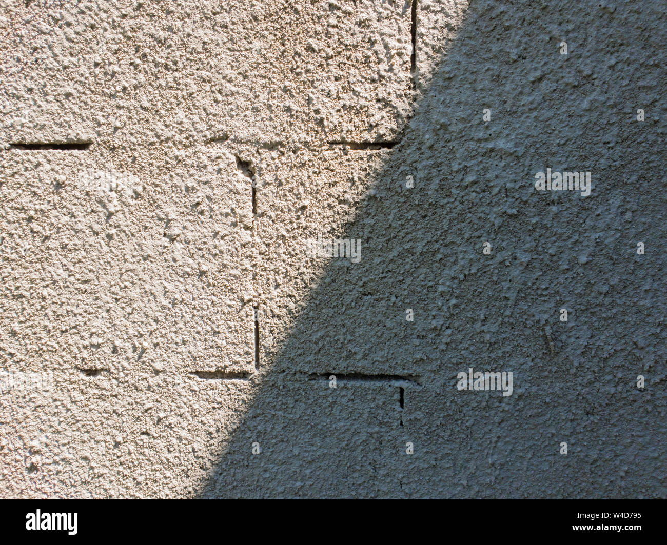 Alten grauen Stein gemauerte Wand Textur aus Schaumstoff Blöcke oder airblocks Split auf zwei Seiten Licht und Schatten. Abstrakte verputzte Oberfläche. Grunge, weathere Stockfoto