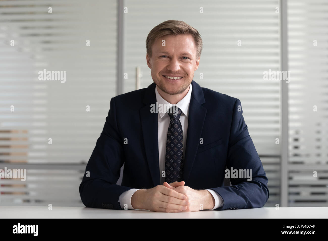 Lächelnd im mittleren Alter Geschäftsmann Trainer im Anzug an Kamera suchen Stockfoto