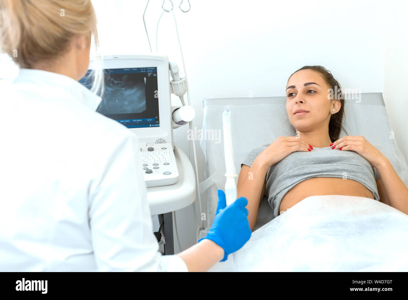 Der frauenarzt stellt das Ultraschallgerät und erklärt dem Patienten
