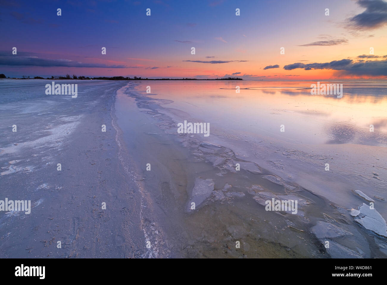 Einen gefrorenen See auf einem kalten Wintern abends am Strand mit Eis im Vordergrund - See IJsselmeer, Niederlande Stockfoto