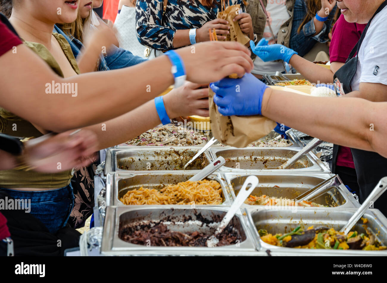 Ein Kunde kauft Lebensmittel aus einem Filipino Straße essen zu einem Philippinischen kulturelle Veranstaltung in London Abschaltdruck Stockfoto