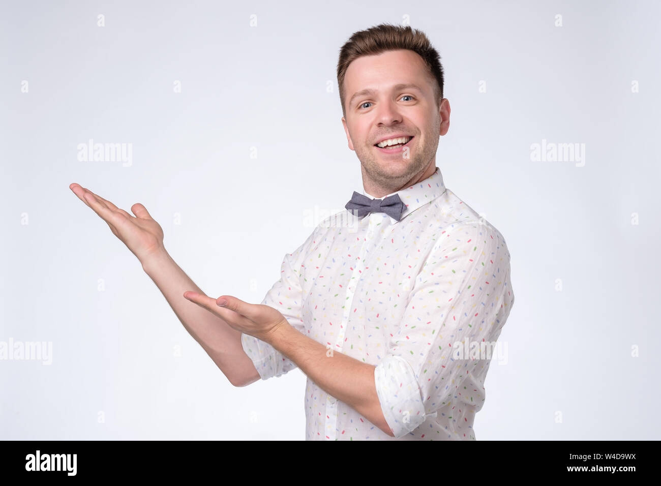 Glücklich Mann an der Kamera suchen, lächeln und zeigte mit der Hand. Stockfoto