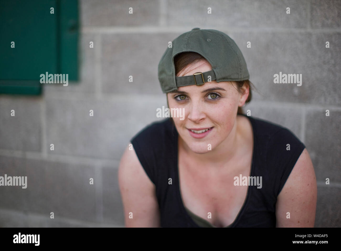 Frau steht neben Betonwand Stockfoto