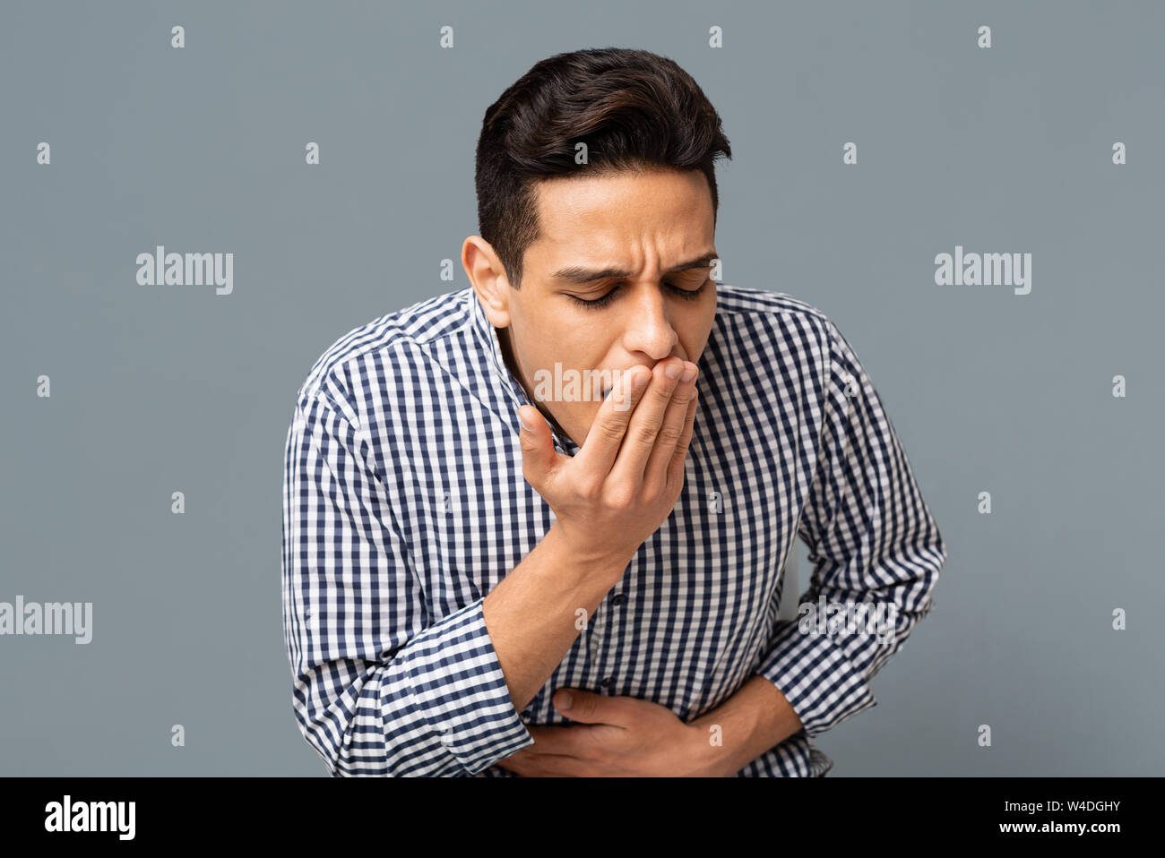 Man Unwohlsein und Übelkeit auf grauem Hintergrund Stockfoto