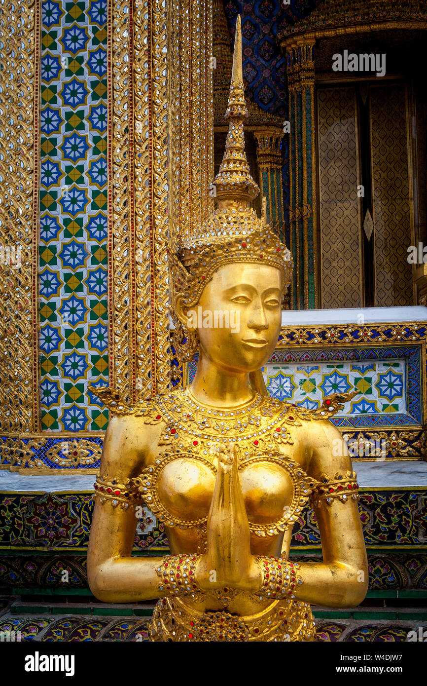 Goldene Figur eines halb Mensch, halb Vogel, ein Kinnara Wachen der Tempel des Smaragd Buddha im Grand Palace in Bangkok, Thailand. Stockfoto