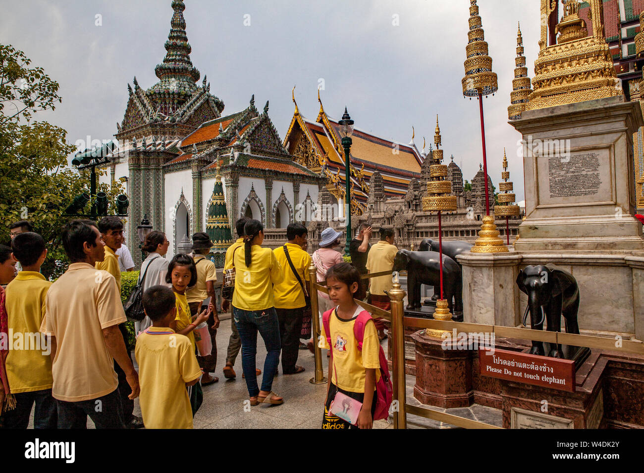 Touristen im Grand Palace in der Nähe der Tempel des Emerald Buddha in Bangkok, Thailand. Stockfoto