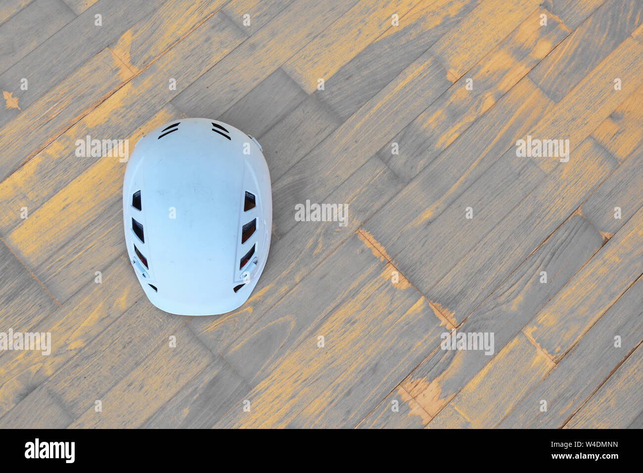 Weiß klettern Helm (auch in alpinen oder Industriebauten benutzt) auf Holz- Hintergrund mit diagonalen Holzbohlen in Grau und Orange. Kopieren spac Stockfoto