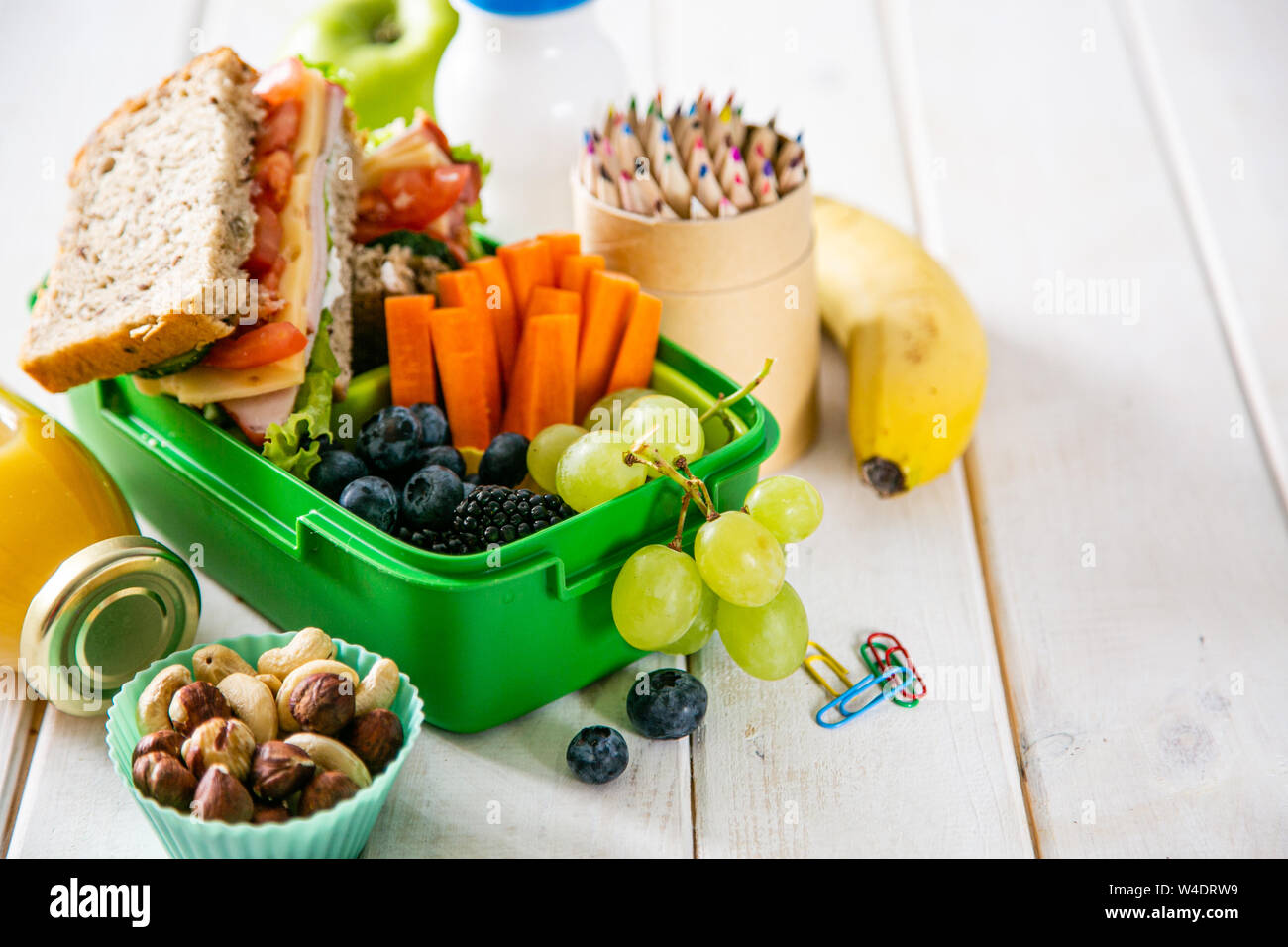 Zurück zum Konzept der Schule - Lunch Box mit Saft, Apfel und Banane Stockfoto