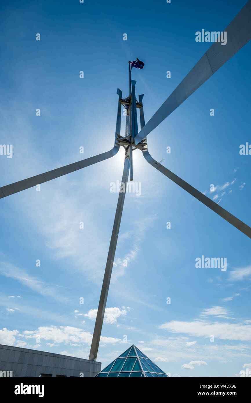 Die Sonne ist hinter dem vierbeinigen Fahnenmast auf dem Dach des Australien Parliament House in Canberra verborgen, Stockfoto