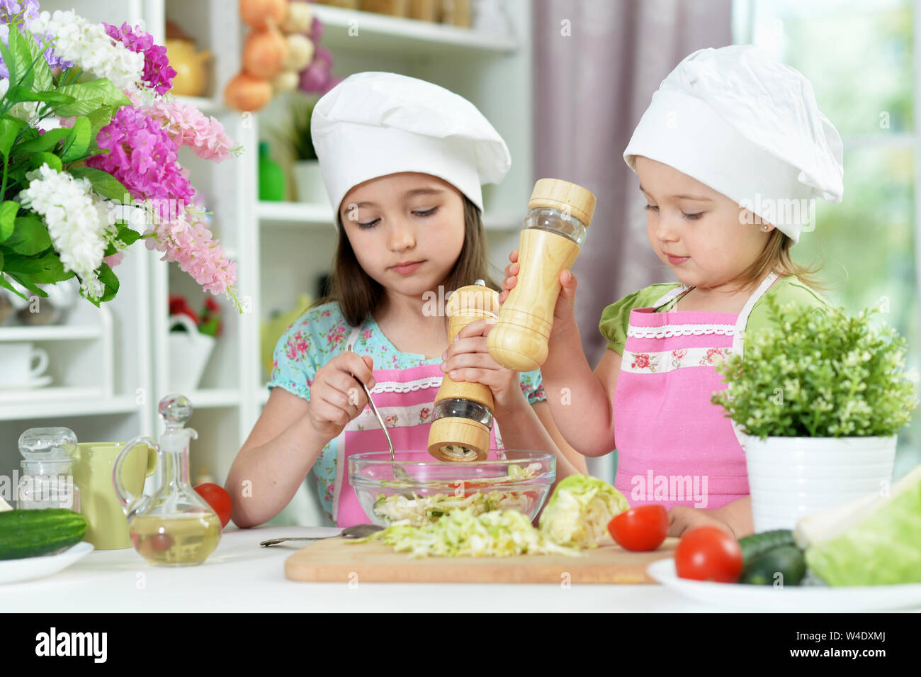 Nette Mädchen bereitet köstliche frische Salat in der Küche Stockfoto