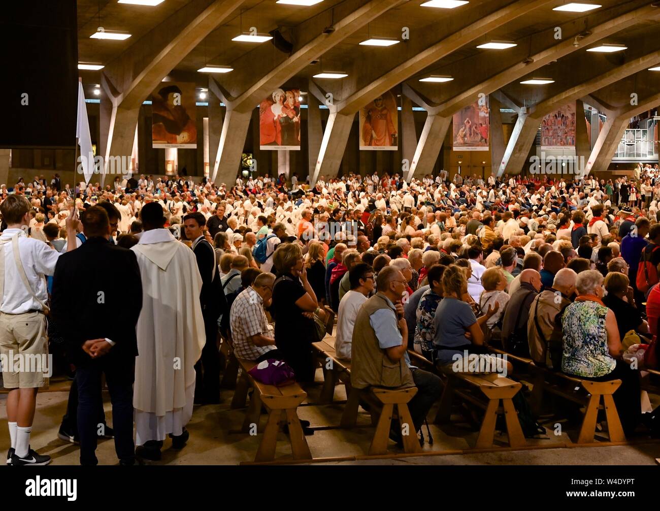 Die Teilnahme an der internationalen Messe in der unterirdischen Basilika in Lourdes, Frankreich Stockfoto