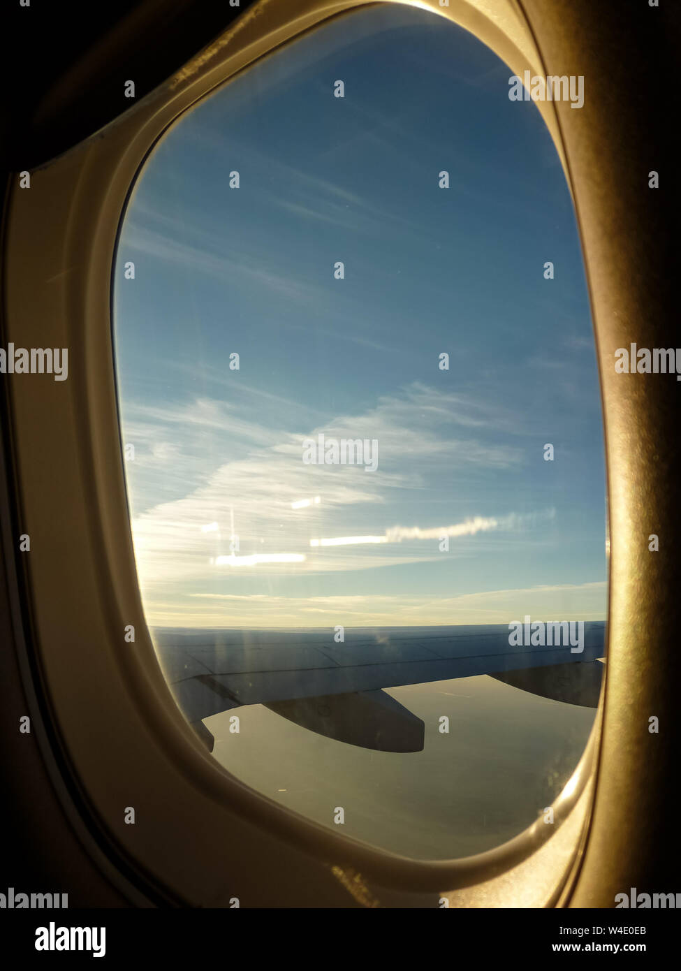 Flugzeug Fenster mit Luftaufnahme von flugzeugflügel und Himmel mit Wolken Stockfoto