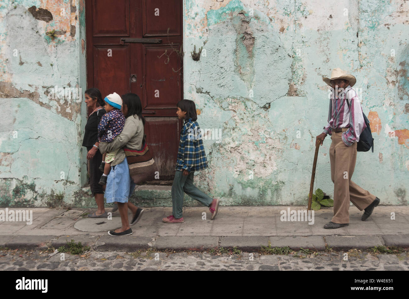 Guatemala, Antigua, street scene mit Familie farbenfrohes Gebäude vorbei gehen. Stockfoto
