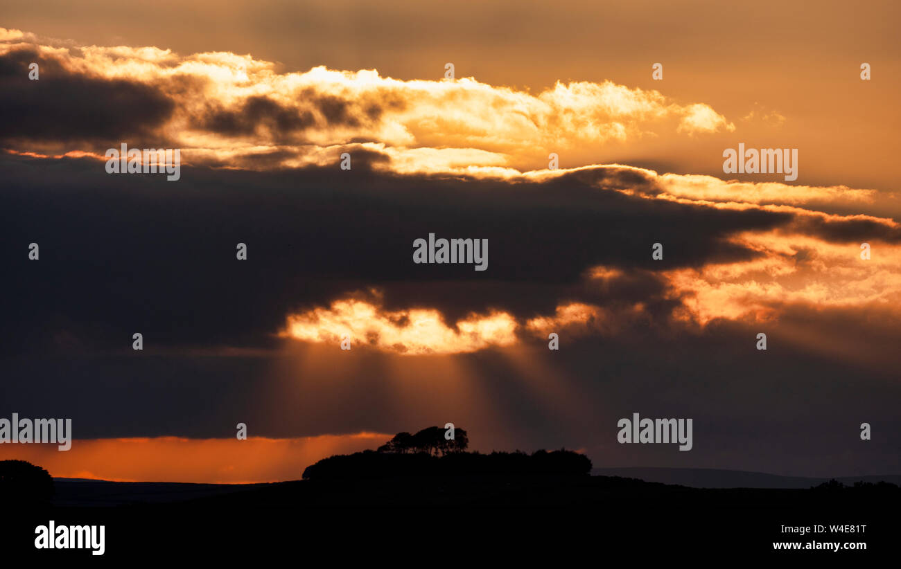 Wetter in Großbritannien: Spektakuläre moody Sonnenuntergang über Minning niedrigen Hügel historischen England Monument mit einem chambered Grab & zwei Schüssel schubkarren von harboro Felsen, Peak District, UK gesehen Stockfoto