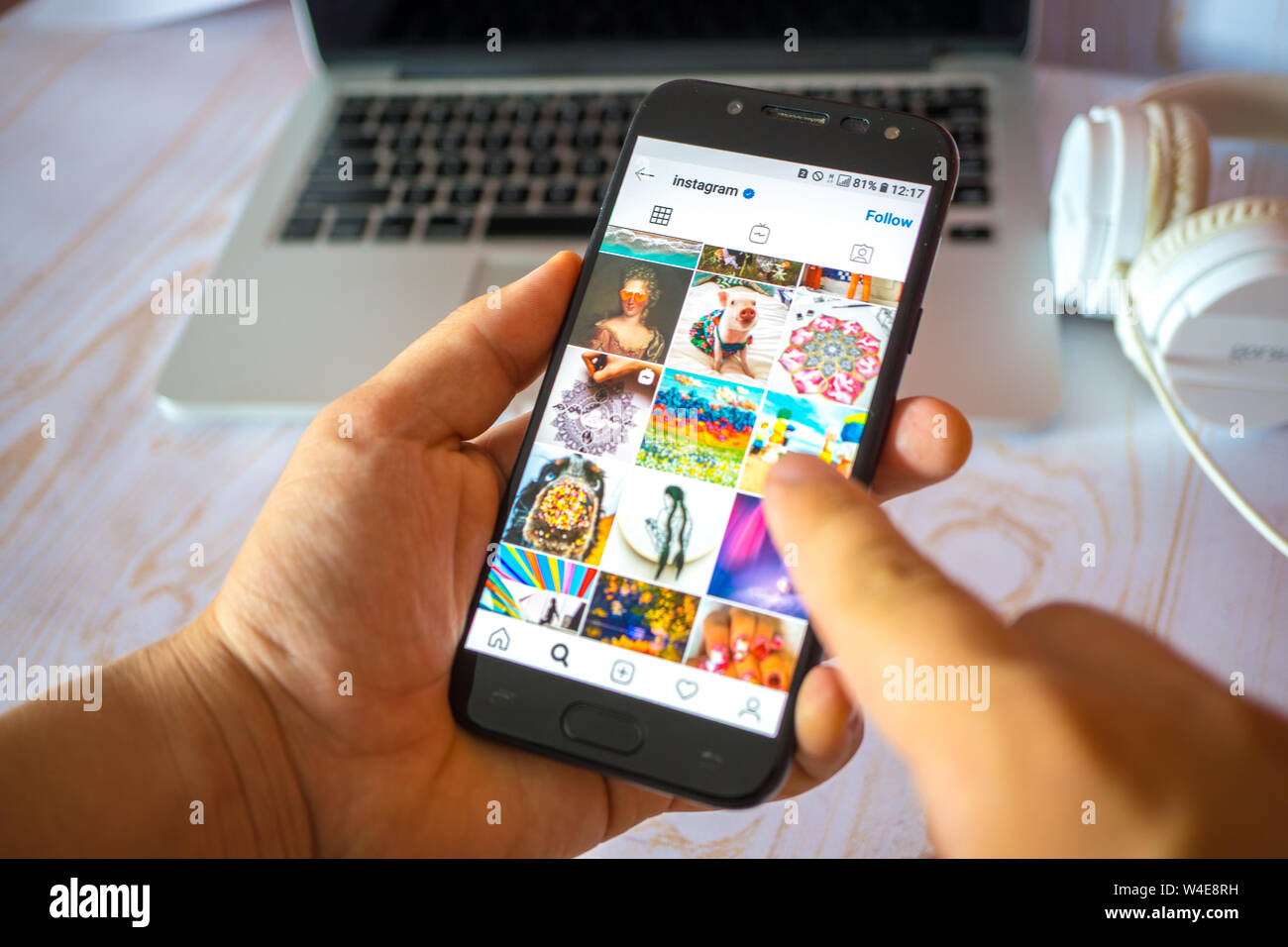 Nizhyn, Ukraine/Juli -16-2019: junger Mann in Schwarz suite halten Sie das Smartphone und Instagram app verwenden, und verweist auf den Bildschirm mit dem Finger. Soziale Medien Stockfoto