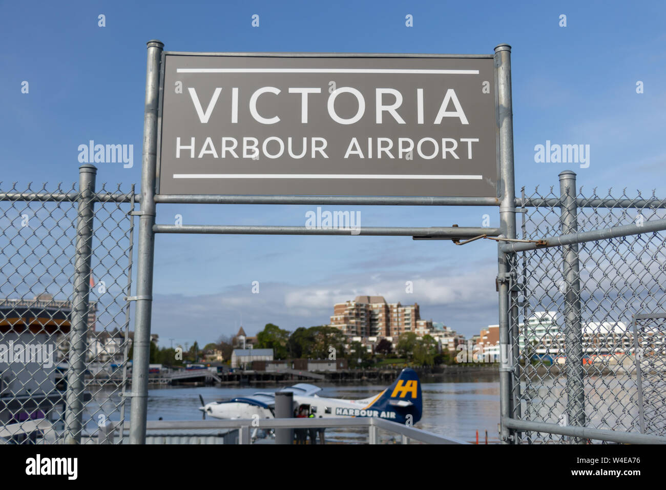 Schild zum Flughafen Victoria Harbour über der Einfahrt zum Terminal mit einem unten angedockten Harbor Air Seaplane. Stockfoto