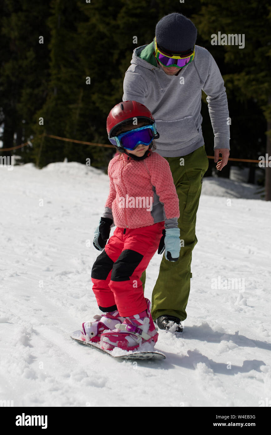 Kleine süße Mädchen Snowboarden die Tricks bei Ski Resort im sonnigen Wintertag. Kaukasus Berge. Mount Hood Meadows Oregon Stockfoto