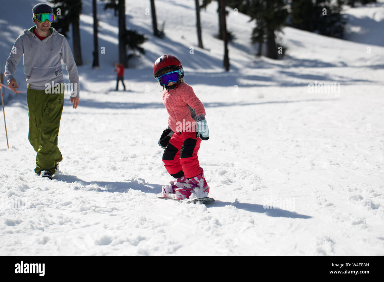 Kleine süße Mädchen Snowboarden die Tricks bei Ski Resort im sonnigen Wintertag. Kaukasus Berge. Mount Hood Meadows Oregon Stockfoto