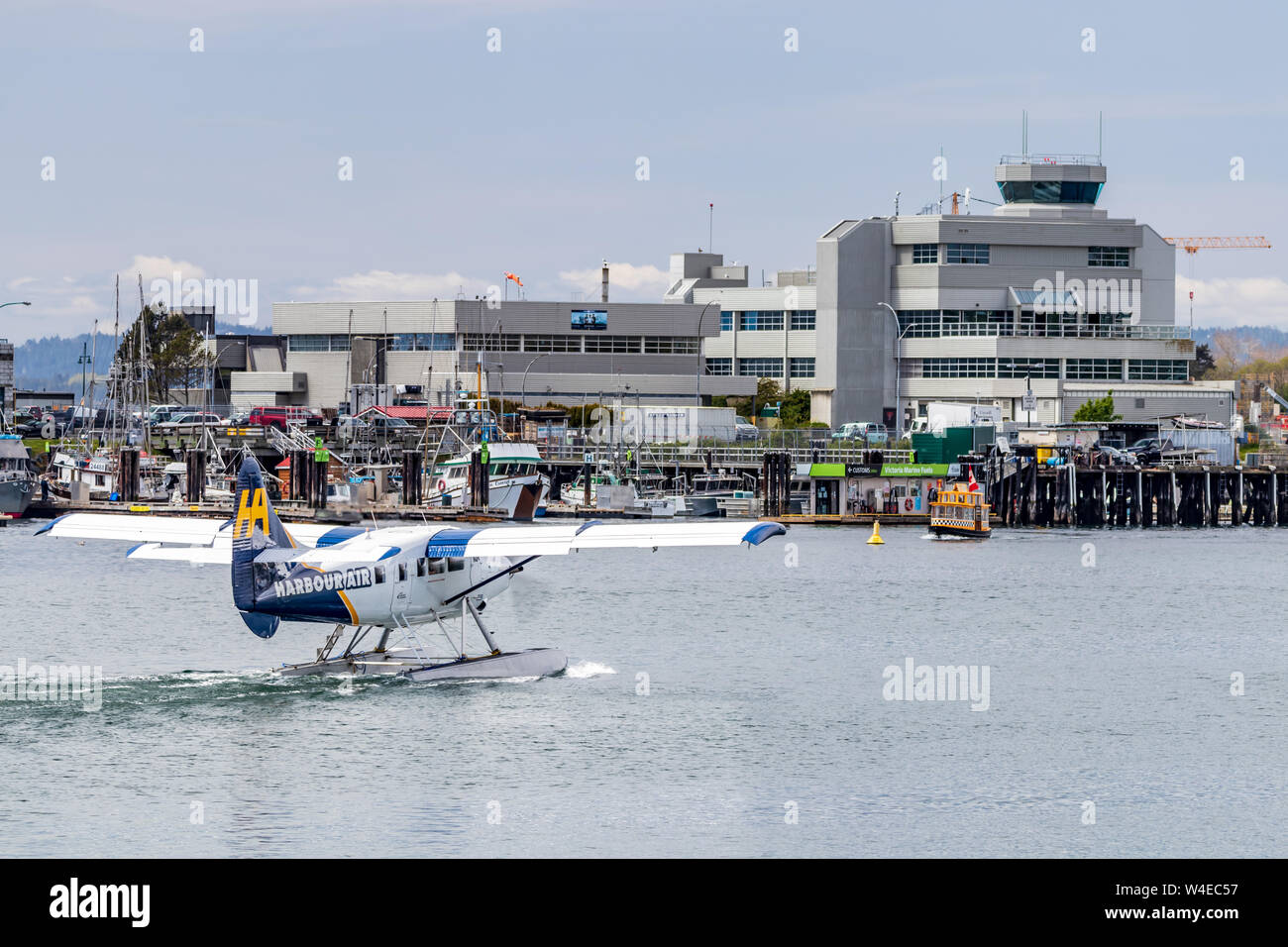 Harbor Air Wasserflugzeug Rollen durch die Innenstadt von Victoria, BC Hafen Kontrollturm. Stockfoto