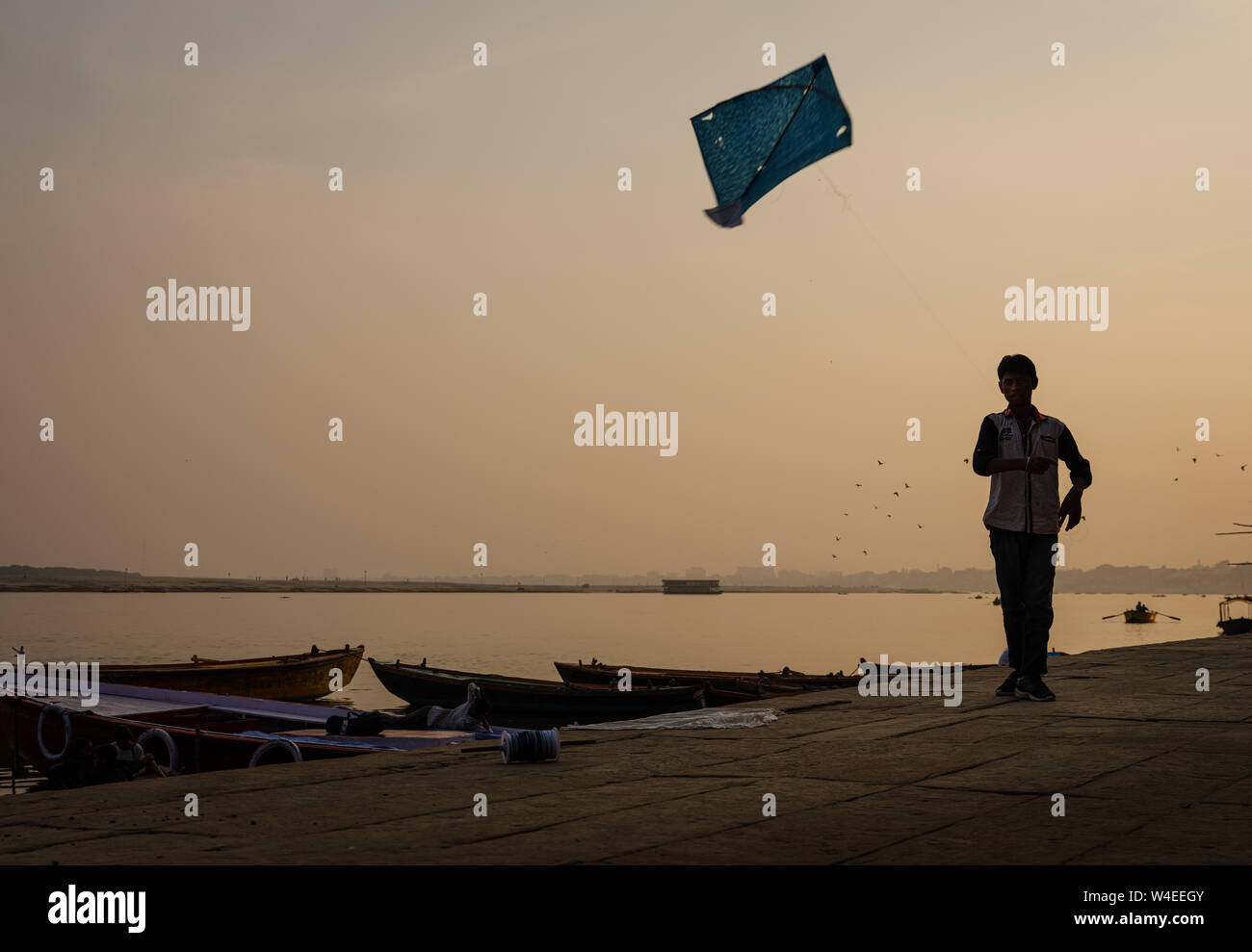 Varanasi, Indien - ca. November 2018: Junge Kinder fliegende Drachen über den Ghats des Ganges in Varanasi. Varanasi ist die geistige Hauptstadt von Indien, Stockfoto