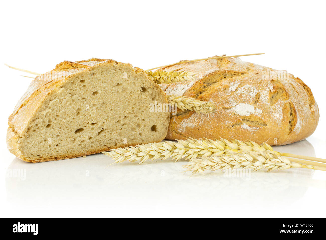 Gruppe von einem halben Ganz, frisch gebackene Roggen Weizen Brot mit drei goldenen Weizenähren vor auf weißem Hintergrund Stockfoto