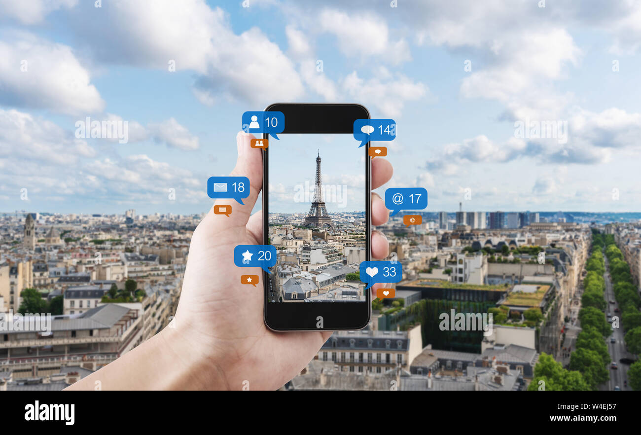 Hand mit smart phone unter Foto der Eiffelturm in Paris, Frankreich mit Social Media und Social Network Benachrichtigungssymbole Stockfoto