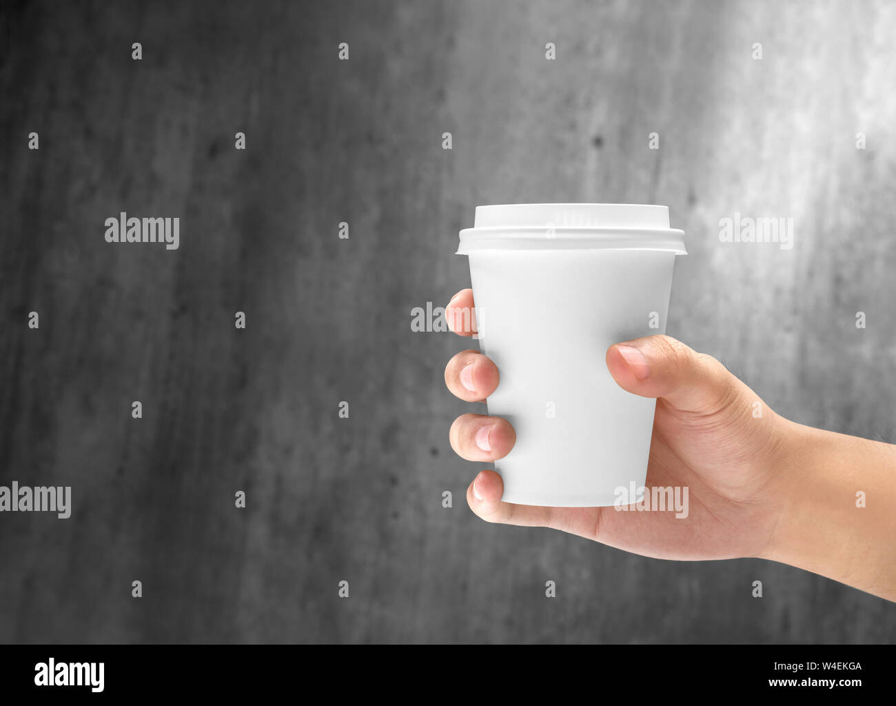 Hand mit einem Styropor Tasse heißen Kaffee auf der hölzernen Wand Hintergrund Stockfoto