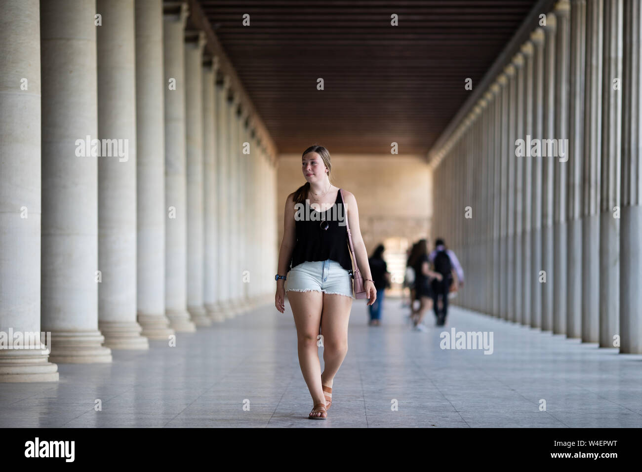 Eine junge weibliche kaukasischen Modell posiert für Fotos in der Stoa des Attalos in die Antike Agora von Athen, Griechenland. Stockfoto