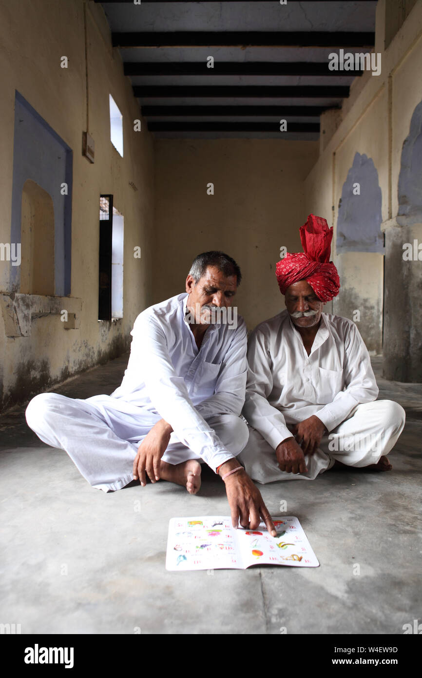 Zwei alte Männer am Boden sitzen und ein Buch zu lesen Stockfoto