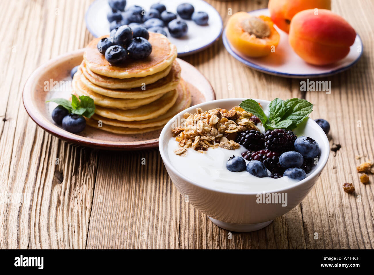 Gesundes Frühstück oder Brunch, Liebling morgen Mahlzeit. Hausgemachtes  Müsli mit Joghurt, Pfannkuchen, frischem Sommer Beeren, Früchte, Marmelade  auf hölzernen Tisch Stockfotografie - Alamy