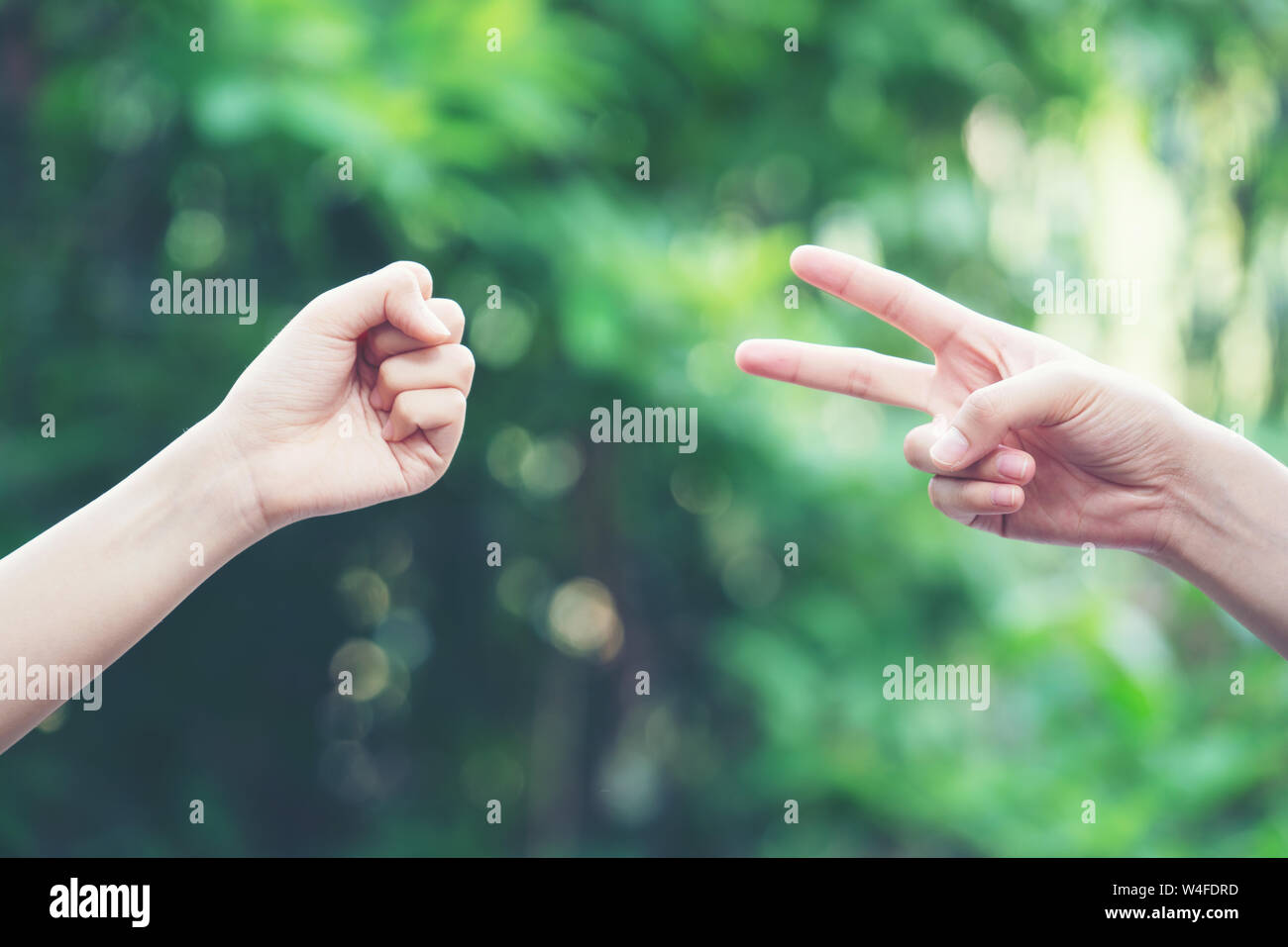 Paar spielen Rock Paper Scissors hand Spiel der Natur grüner Hintergrund Stockfoto