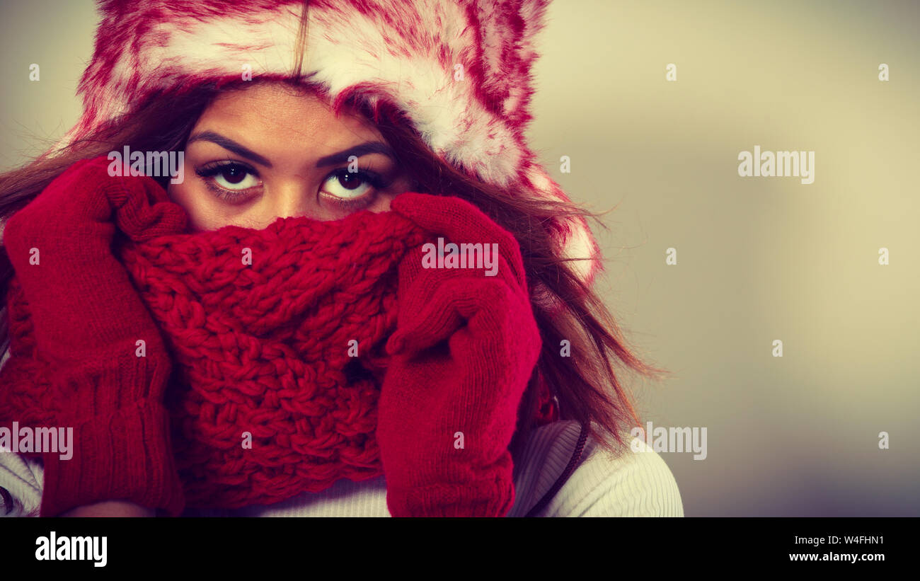 Mode, verschneiten Menschen zeit Konzept. Frau mit roten Winterkleidung. Mulatte Modell tragen warme Mütze und Schal Stockfoto