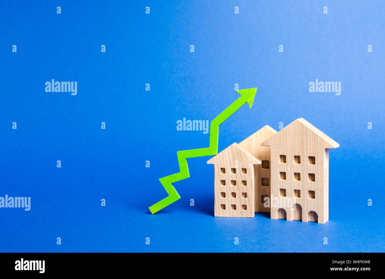 Zahlen von Wohngebäuden und grünen Pfeil nach oben. Wachstum der Nachfrage und Liquidität für Immobilien, Erhöhung der Preise für die Instandhaltung der Gebäude Stockfoto