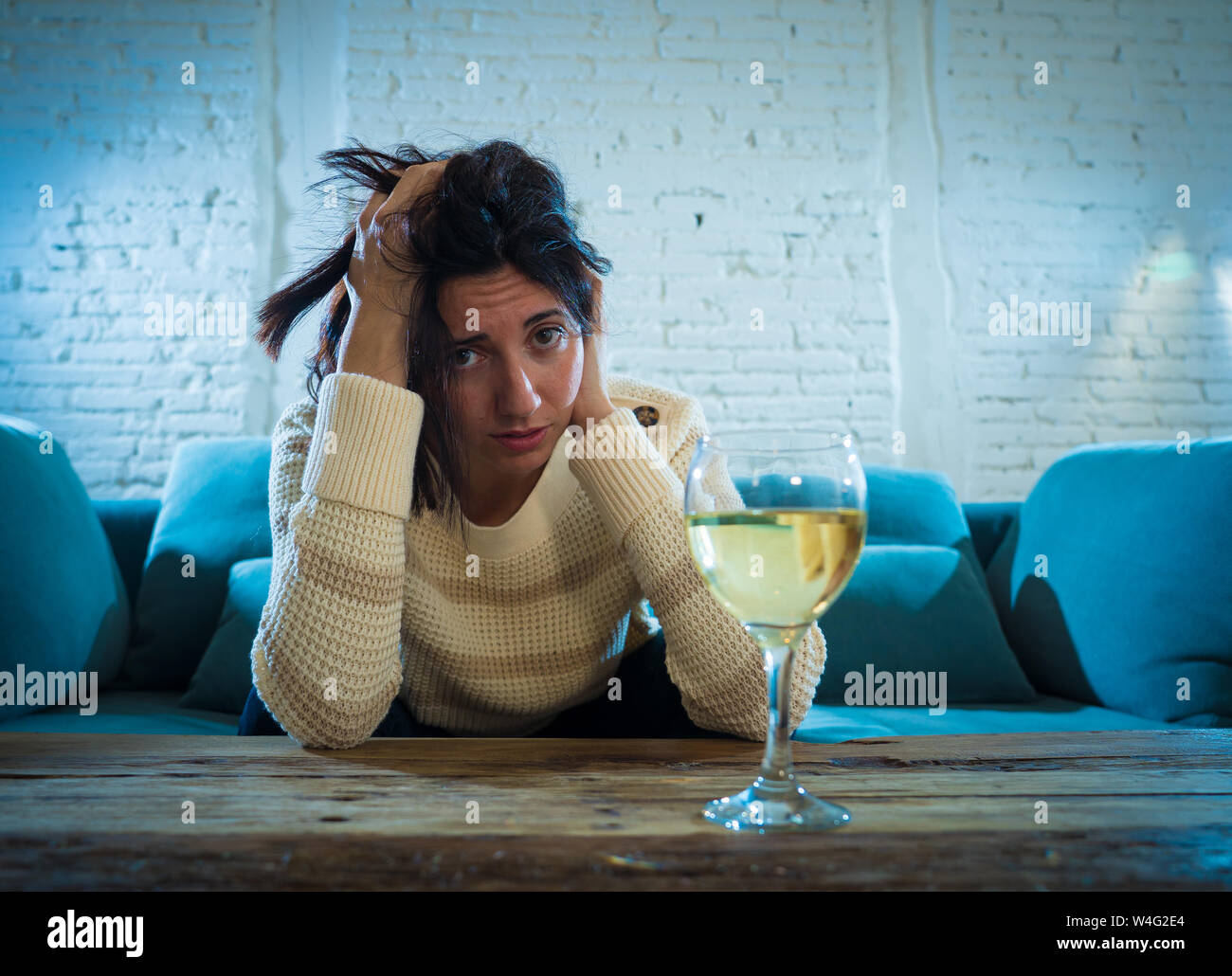 Betont und hoffnungslose junge Frau trinkt ein Glas Wein allein zu Hause. Deprimiert, frustriert und schwach, versuchen, besser trinken zu fühlen. Unhe Stockfoto