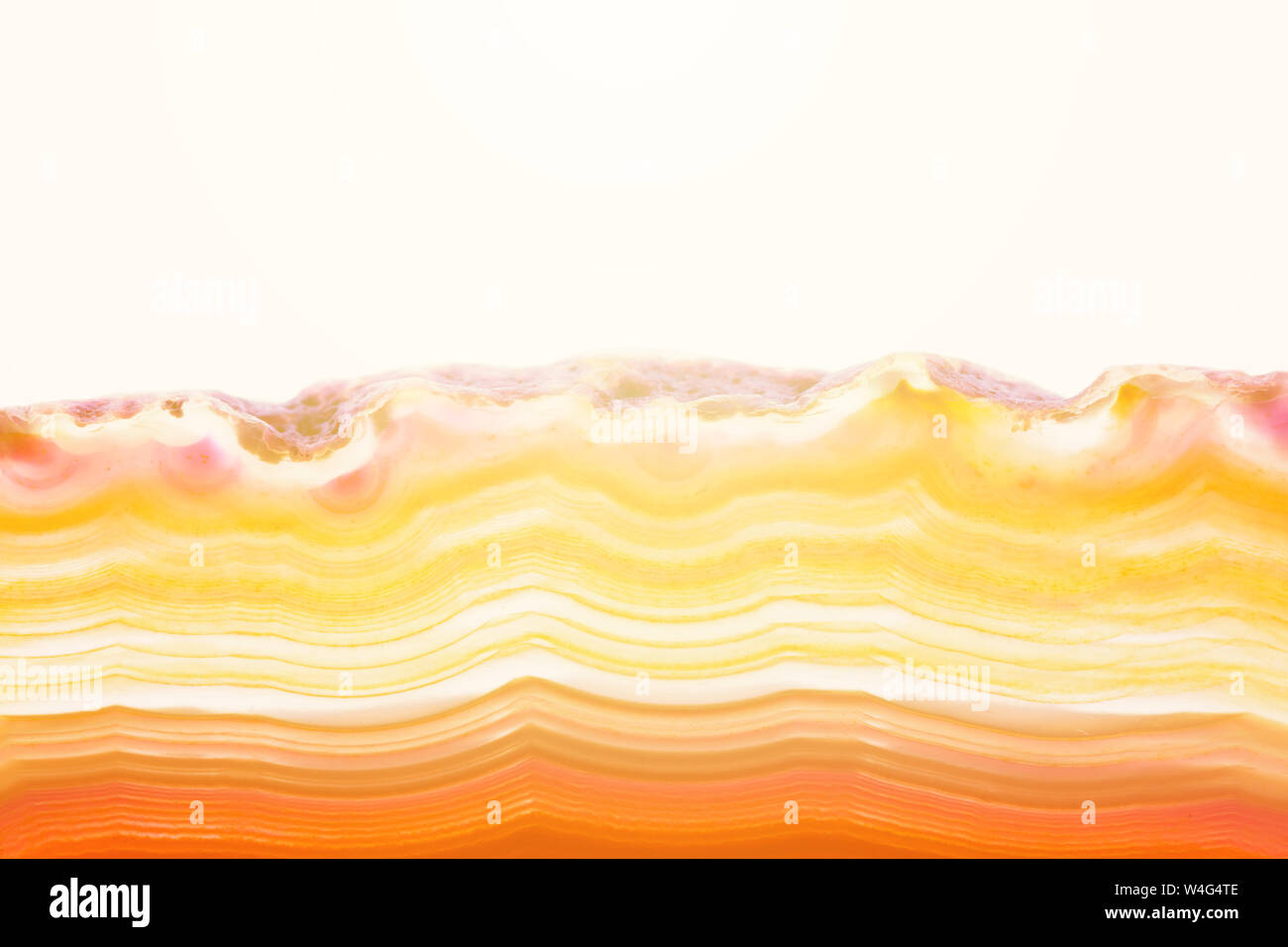 Zusammenfassung Hintergrund, orange und gelb gestreifte mineral Achat Querschnitt mit Sunbeam auf weißem Hintergrund Stockfoto
