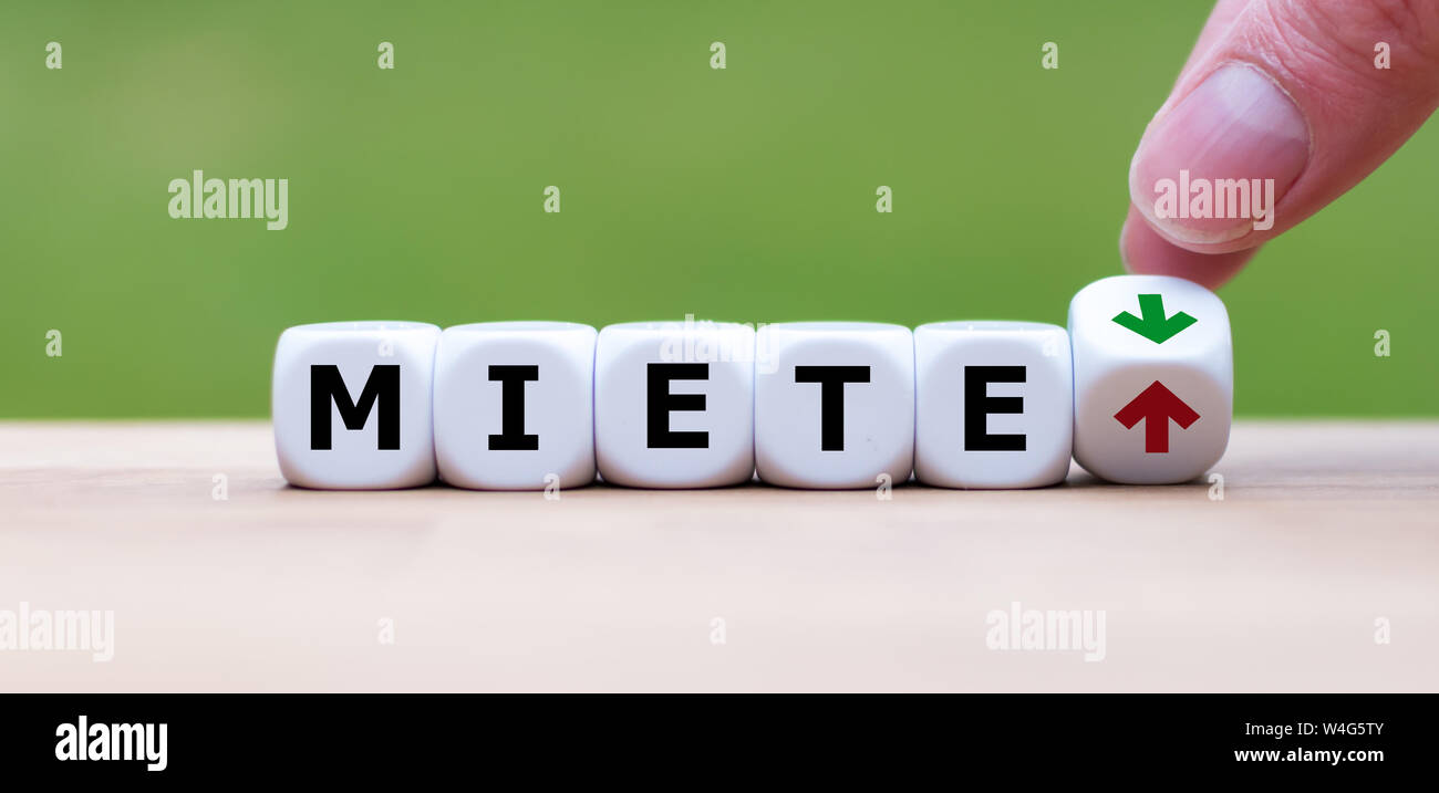 Symbol für steigende Mieten. Würfel Form das deutsche Wort 'Miete' ('Rent" auf Englisch). Eine Hand verwandelt einen Würfel und verändert die Richtung, in die sich ein Pfeil. Stockfoto